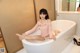 A woman sitting in a bathtub with her legs crossed.