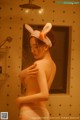 A woman in a bunny hat is taking a shower.