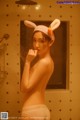 A woman in a bunny hat is taking a shower.