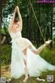 A woman in a white dress is swinging on a swing.