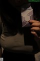 A woman holding up a business card in her hand.