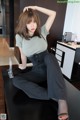 A woman sitting on top of a black table.