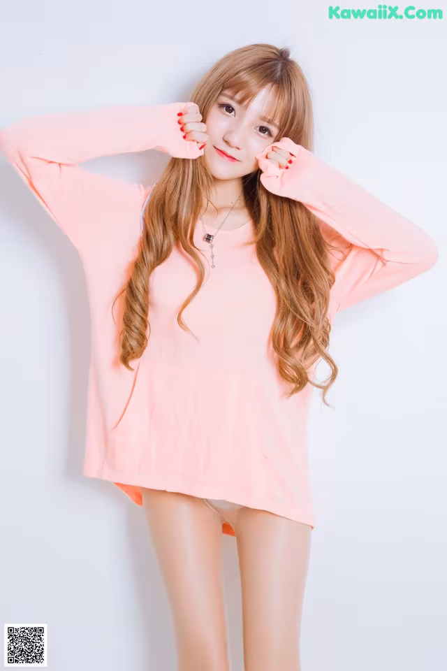 A woman in a pink shirt is posing for a picture.