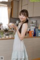 A woman holding a plate of food in a kitchen.