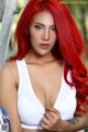 A woman with red hair wearing a white bra top.