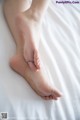 A close up of a person's feet on a bed.